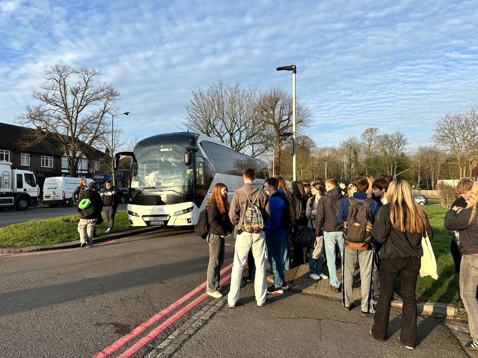 A student group waiting beside their coach at the Shirley meeting point